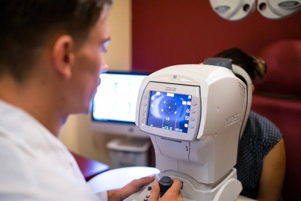 Optometrista durante la misurazione della vista con autorefrattometro